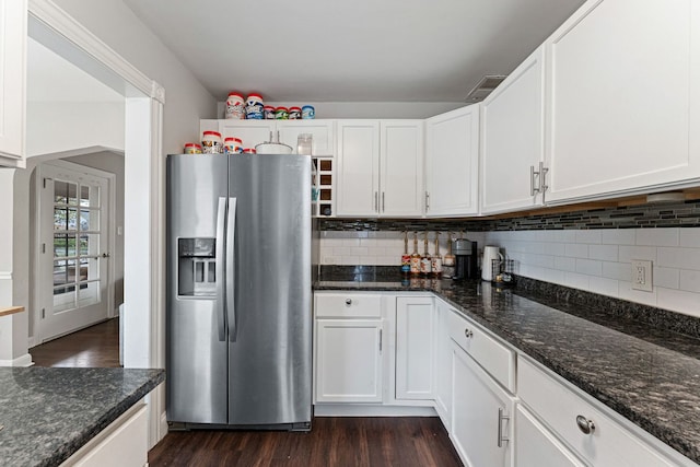 kitchen with white cabinets, stainless steel fridge, dark hardwood / wood-style flooring, and dark stone counters