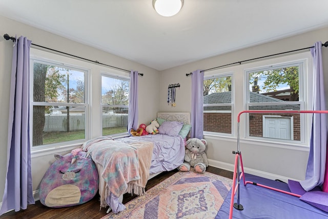 bedroom with multiple windows and hardwood / wood-style floors