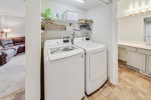 laundry area with sink, light colored carpet, and separate washer and dryer