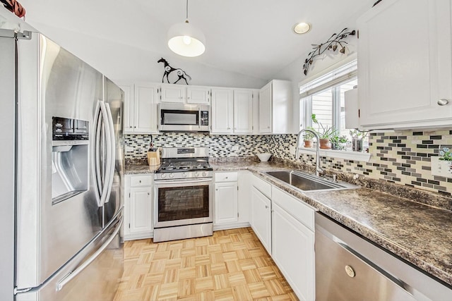 kitchen featuring sink, white cabinets, vaulted ceiling, and appliances with stainless steel finishes