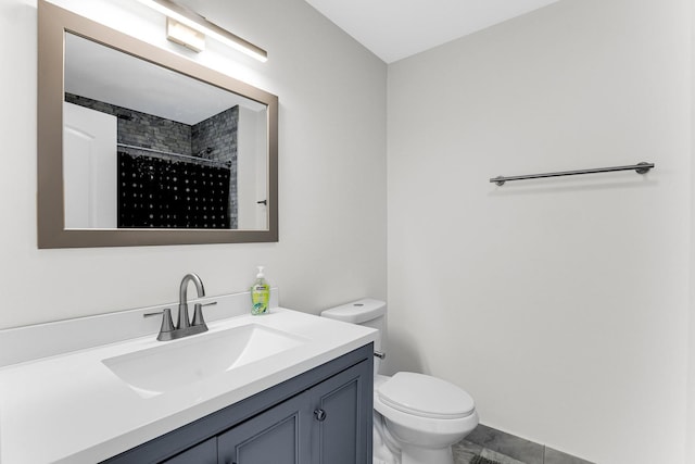 bathroom featuring a shower, vanity, and toilet