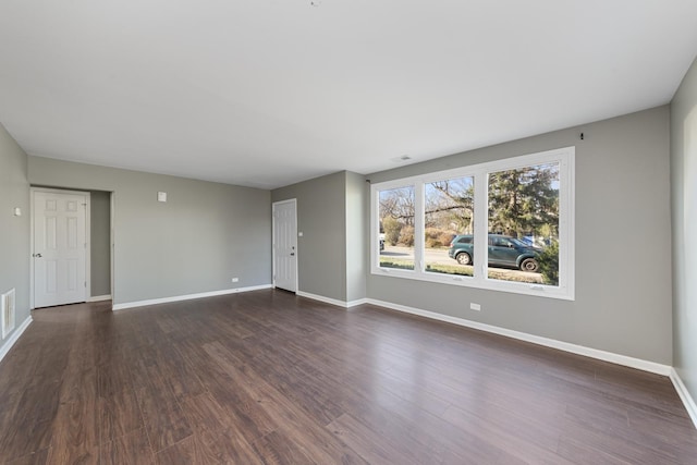 empty room with dark hardwood / wood-style flooring