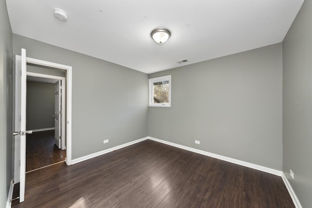 spare room featuring dark wood-type flooring