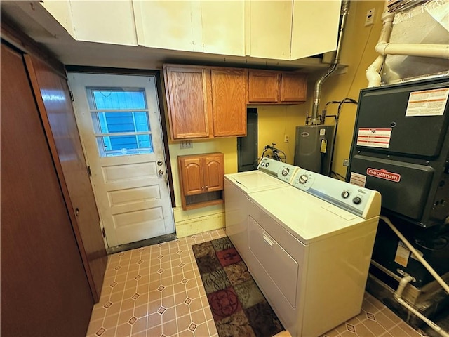 laundry room featuring water heater, washer and clothes dryer, and cabinets