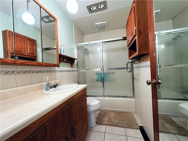 full bathroom featuring tile walls, shower / bath combination with glass door, and toilet