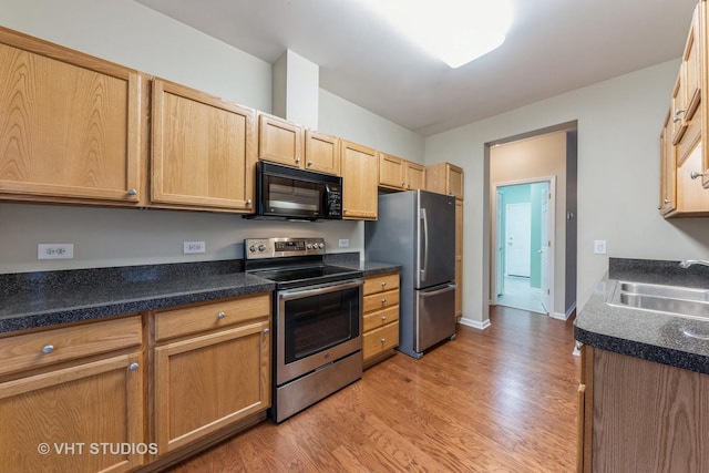 kitchen featuring sink, light wood-type flooring, light brown cabinets, and appliances with stainless steel finishes