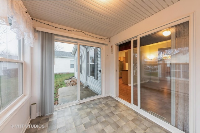 unfurnished sunroom featuring plenty of natural light and wood ceiling