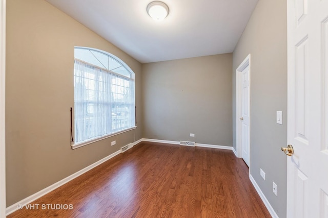 unfurnished room with dark hardwood / wood-style flooring