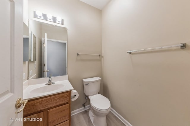 bathroom featuring vanity, wood-type flooring, and toilet