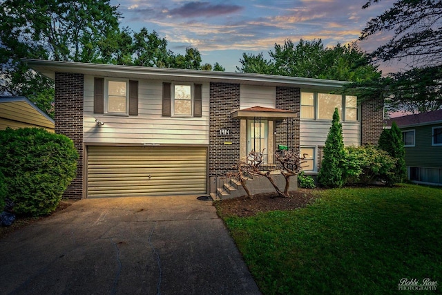 split foyer home with a lawn and a garage