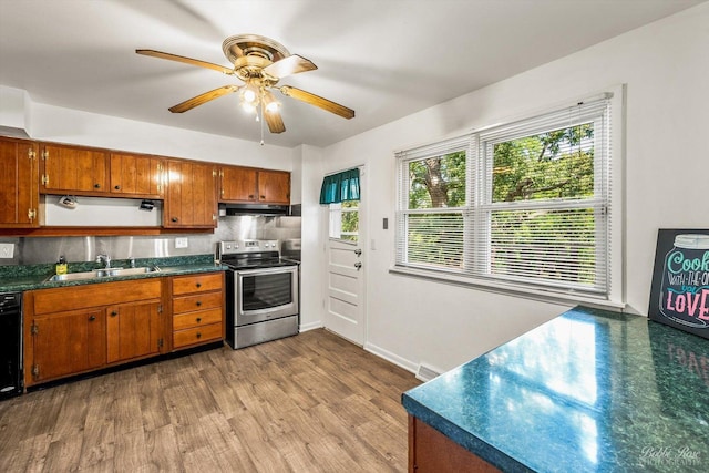 kitchen featuring electric range, sink, ceiling fan, backsplash, and light wood-type flooring