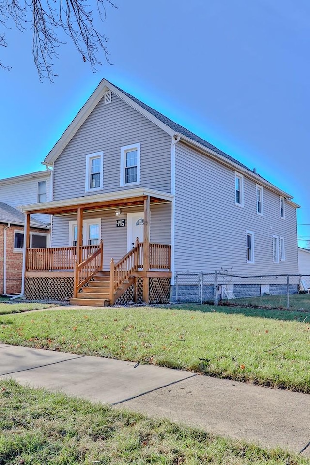 back of house featuring covered porch and a yard