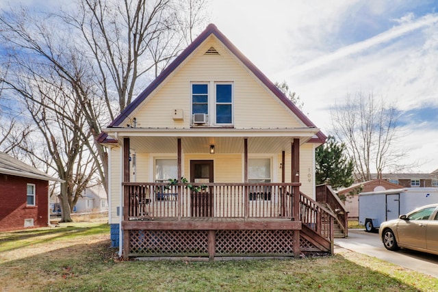 bungalow-style home with covered porch and a front lawn