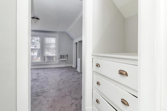 corridor featuring a wall mounted air conditioner, cooling unit, light carpet, and vaulted ceiling