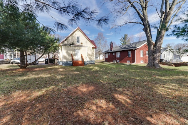 rear view of property featuring a lawn