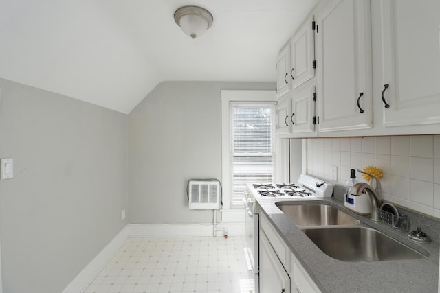 kitchen featuring sink, an AC wall unit, white cabinets, stainless steel stove, and lofted ceiling