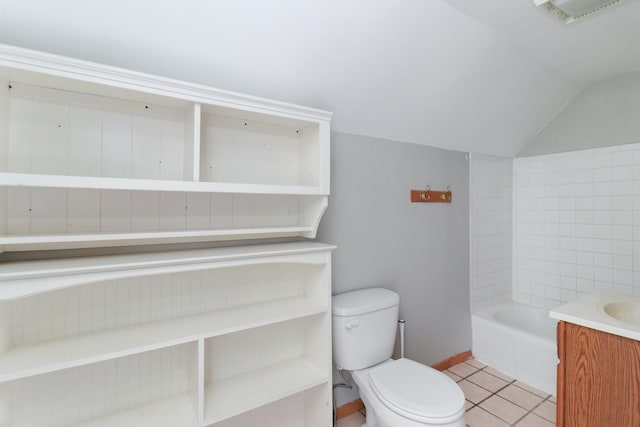 bathroom with tile patterned flooring, vaulted ceiling, toilet, a bathtub, and vanity