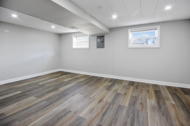 basement with dark hardwood / wood-style flooring, electric panel, and plenty of natural light