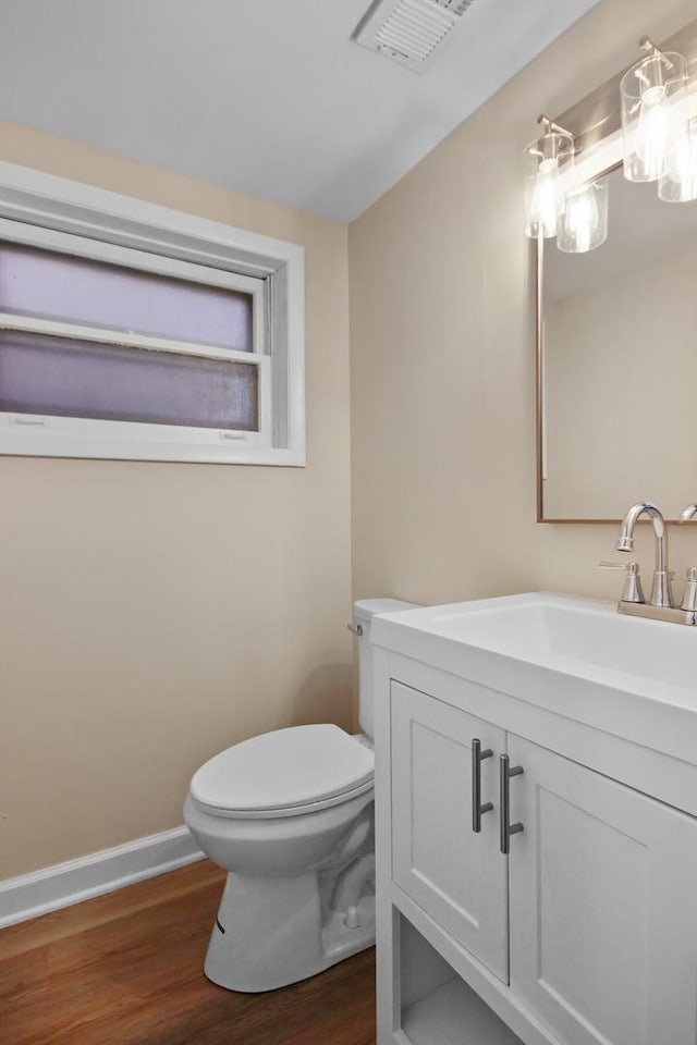 bathroom with hardwood / wood-style flooring, vanity, and toilet