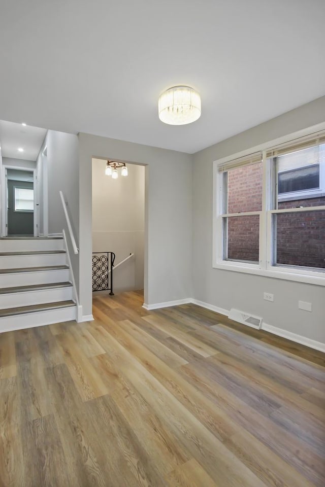 empty room with plenty of natural light and light hardwood / wood-style floors