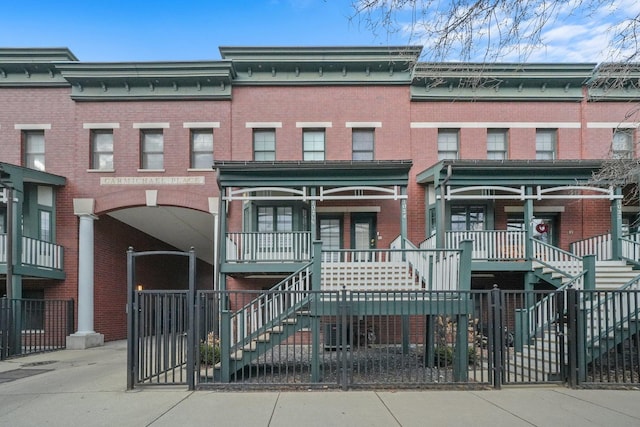 view of front of house with stairway and brick siding