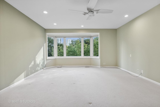 carpeted spare room featuring ceiling fan