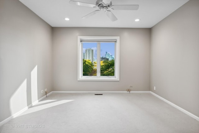 empty room featuring ceiling fan and light carpet