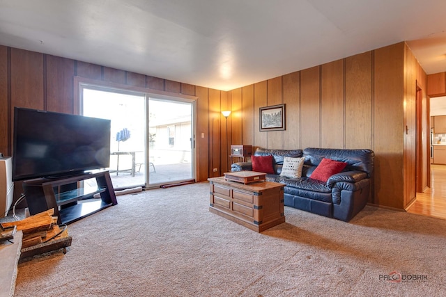 carpeted living room with wooden walls