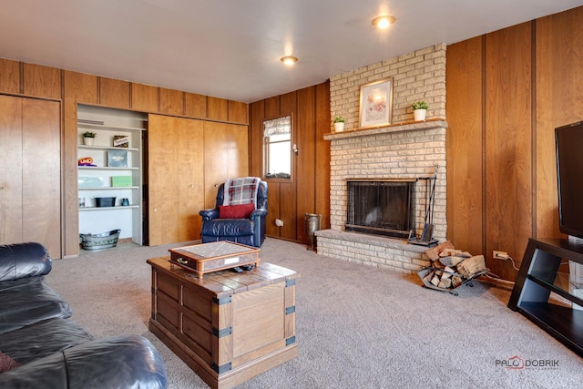 carpeted living room with built in features, a fireplace, and wooden walls