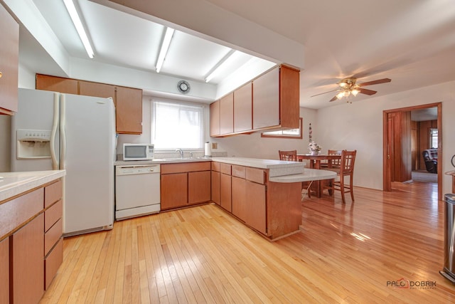 kitchen with kitchen peninsula, sink, ceiling fan, light hardwood / wood-style floors, and white appliances