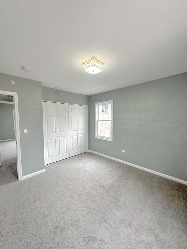 unfurnished bedroom with a closet and carpet floors