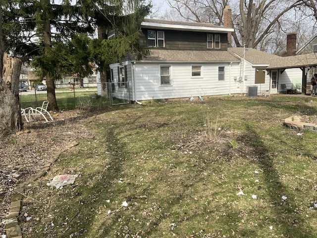 rear view of house with a lawn and central air condition unit