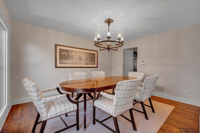 dining room with a notable chandelier and hardwood / wood-style flooring