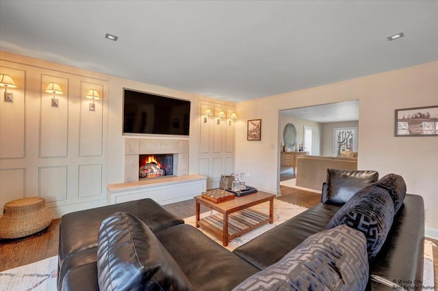 living room with a tile fireplace and light hardwood / wood-style floors