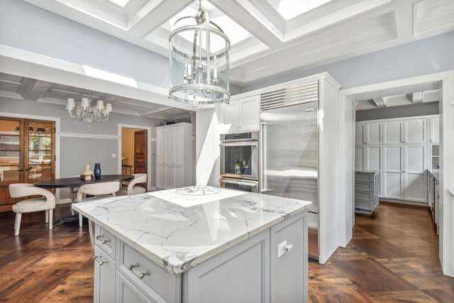 kitchen featuring pendant lighting, dark parquet floors, a kitchen island, and built in fridge