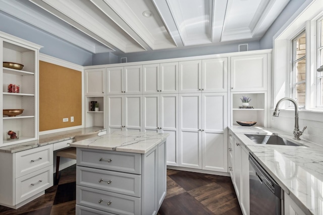 kitchen with light stone countertops, stainless steel dishwasher, sink, built in desk, and white cabinetry