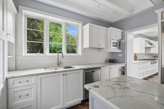 kitchen featuring light stone counters, sink, white cabinets, and extractor fan