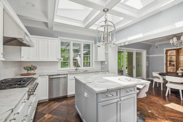 kitchen featuring decorative light fixtures, white cabinetry, stainless steel appliances, and coffered ceiling