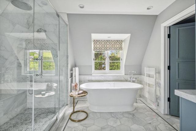 bathroom featuring vaulted ceiling, separate shower and tub, and tile walls