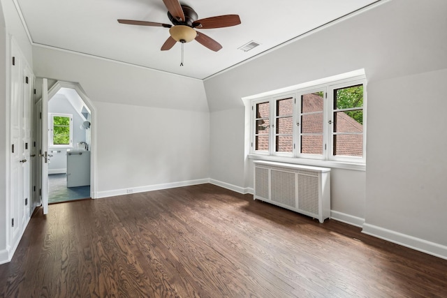 interior space with radiator, vaulted ceiling, ceiling fan, dark wood-type flooring, and sink