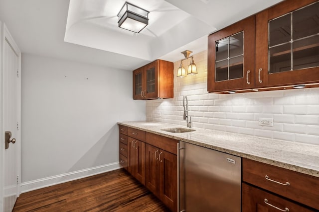 kitchen featuring dishwasher, sink, dark hardwood / wood-style floors, decorative light fixtures, and light stone counters