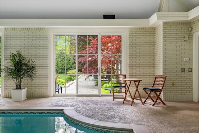 interior space with carpet flooring and brick wall