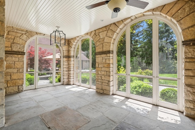 unfurnished sunroom featuring ceiling fan