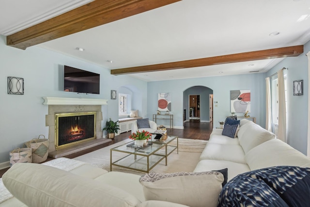 living room with beamed ceiling, dark hardwood / wood-style flooring, and a premium fireplace