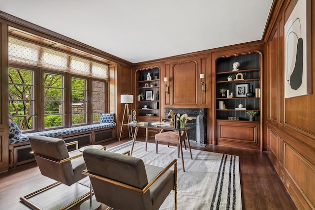 sitting room featuring dark hardwood / wood-style flooring, built in features, and ornamental molding