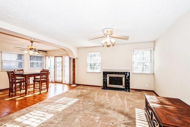 living room with light carpet, a textured ceiling, and ceiling fan