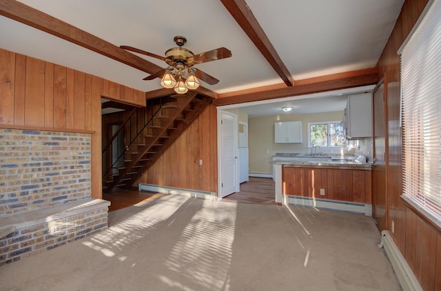 unfurnished living room featuring a baseboard radiator, hardwood / wood-style flooring, and wooden walls