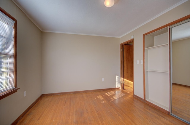 unfurnished bedroom featuring a closet, ornamental molding, and light hardwood / wood-style flooring