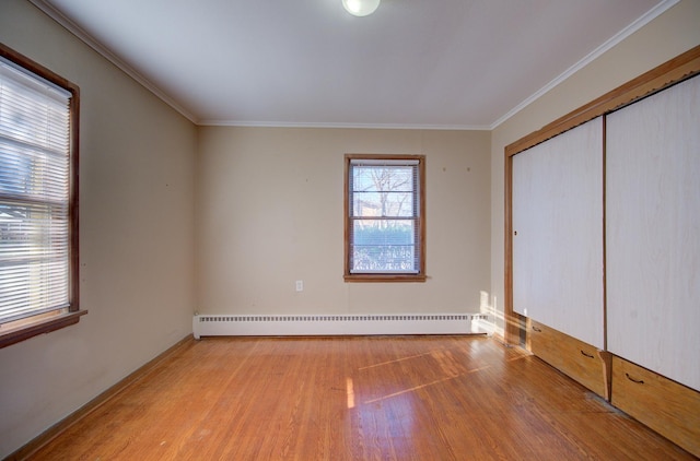 unfurnished bedroom featuring a closet, ornamental molding, light hardwood / wood-style flooring, and a baseboard radiator