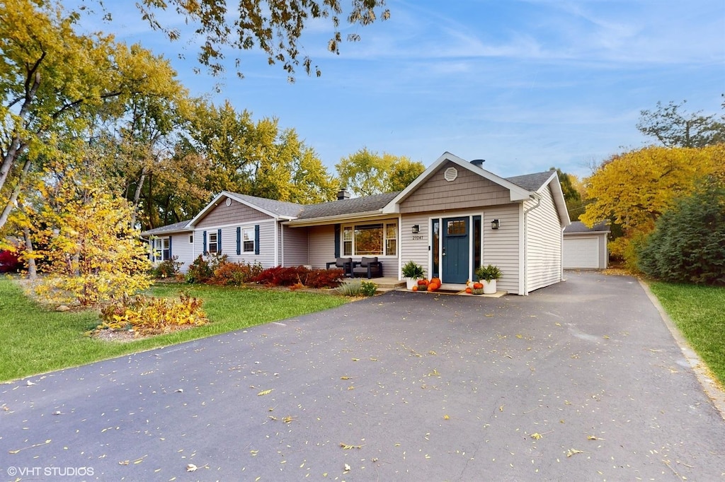 view of front of property with a front lawn, an outdoor structure, and a garage